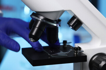 Scientist working with modern microscope indoors, closeup