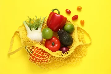 Foto op Plexiglas String bag with fresh vegetables and fruits on yellow background, flat lay © New Africa