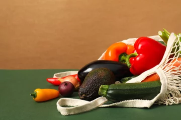 Foto op Plexiglas String bag with fresh vegetables on color background, space for text © New Africa