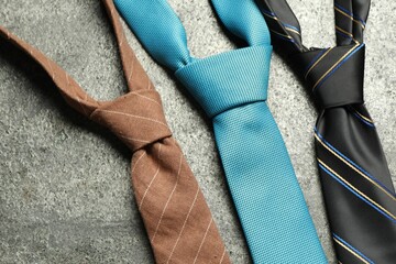 Different neckties on grey textured background, flat lay