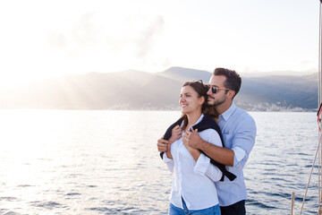 Happy couple in love on vacation on sea beach. Traveling on yacht. Man and woman hugging, enjoying trip. Intimate romantic date on beach. Lifestyle moment. Concept of protection, care, mindfulness