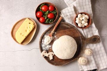 Pizza dough and products on gray textured table, flat lay