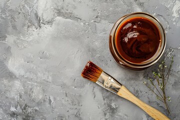 BBQ jar and brush on gray background flat lay Text space available
