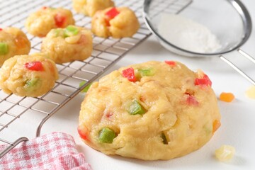 Raw dough with candied fruits on white table, closeup