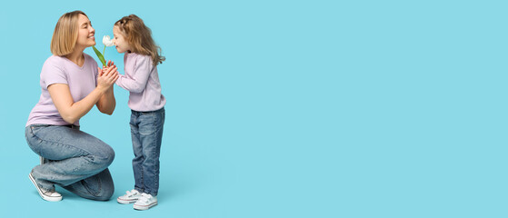 Little girl giving flower to her mother on blue background. Mother's Day