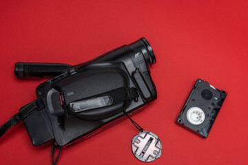 Vintage VHS video camera and a cassette on a red background. retro, 90s