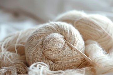 Close up view of light airy beige yarn skein made of baby alpaca and merino wool Knitting needles stuck in