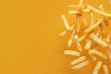 Tasty french fries on orange background