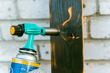 firing of a wooden board with a portable burner and a gas cylinder. Open flame, fire