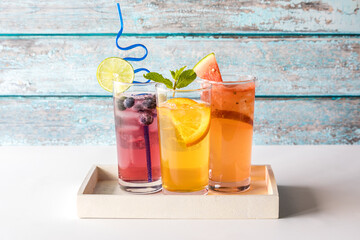 Three refreshing seltzers with various fruit garnishments.