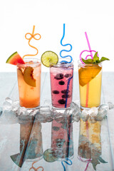 Refreshing flavoured spritzers garnished with fruit and surrounded by ice.
