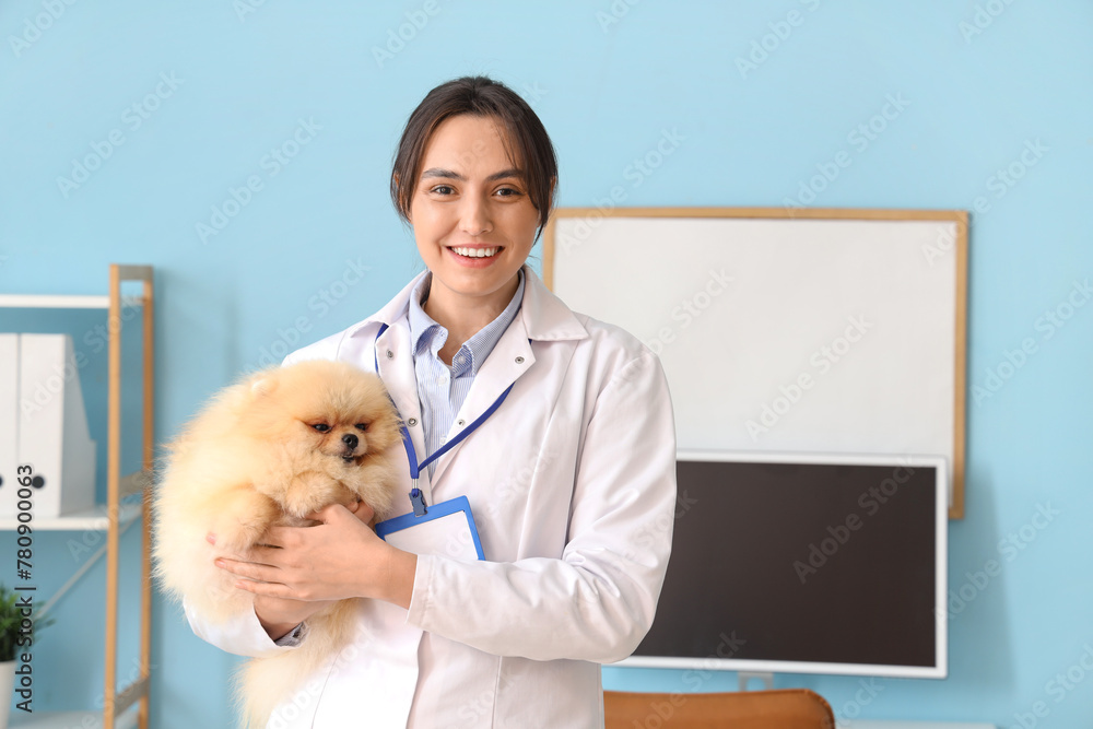 Sticker Female veterinarian with cute Pomeranian dog in clinic