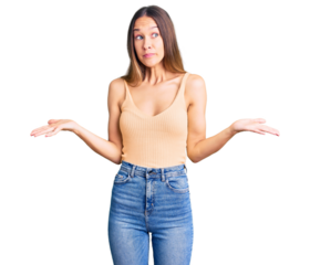 Beautiful brunette young woman wearing casual clothes clueless and confused expression with arms and hands raised. doubt concept.