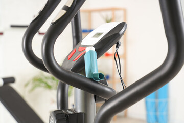 Asthma inhaler on exercise bike in gym, closeup
