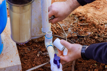 As part of repair work, technician plumber uses clear primer for PVC pipe with before gluing pipes