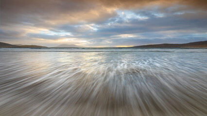 Luskentyre beach at sunset with fast moving tidal water
