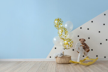 Interior of children's room with bunch of balloons, rocking horse and teddy bear