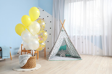Interior of children's room with bunch of balloons and play tent