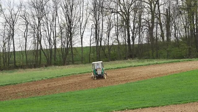 Short clip of farm tractor harrowing arable field