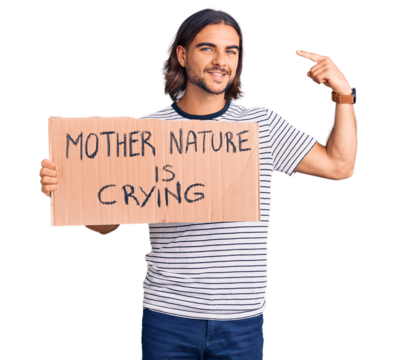 Young handsome man holding mother nature is crying protest cardboard banner pointing finger to one self smiling happy and proud