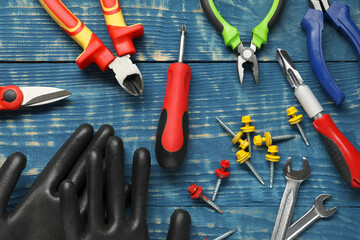 Different pliers, screwdriver and other tools for repair on blue wooden table, flat lay