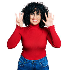 Young middle east girl wearing casual clothes and glasses showing and pointing up with fingers number eight while smiling confident and happy.