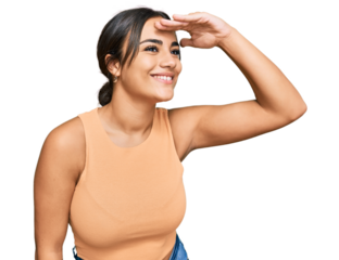 Young brunette woman wearing casual clothes very happy and smiling looking far away with hand over head. searching concept.