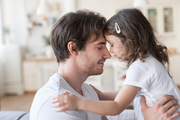 Loving cheerful family, young father and little daughter spending time together, hugging and...