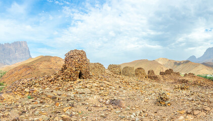 Group of ancient stone beehive tombs with Jebel Misht mountain in the background, archaeological site near al-Ayn, sultanate Oman