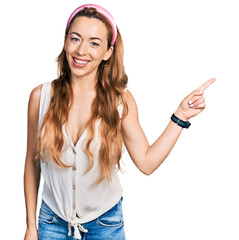 Obraz na płótnie Canvas Young caucasian woman wearing casual style with sleeveless shirt with a big smile on face, pointing with hand finger to the side looking at the camera.
