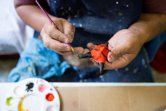 Mexican artisan doing cardboard work on alebrijes