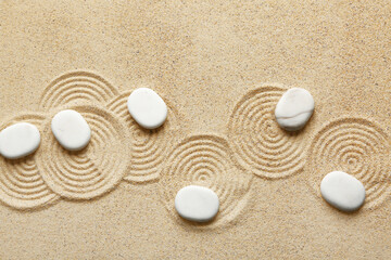 Fototapeta na wymiar Spa stones on light sand with pattern