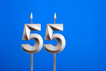 Birthday number 55 - Candle lit on blue background