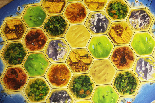Mozyr, Belarus, April 01 2024: A catan board game with yellow and white player figures placed on display. Family time. Board Games Day