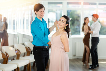 Fototapeta na wymiar Young man and young woman dance ballroom dance waltz in studio