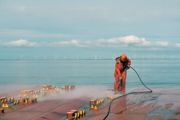 Safety Equipped Crew Seaman Working On Deck With Jet Water Blast Machine Gun To Remove Prevent...