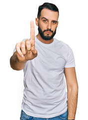 Fototapeta premium Young man with beard wearing casual white t shirt pointing with finger up and angry expression, showing no gesture