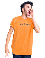 Young hispanic man wearing t shirt with happiness word message shouting and screaming loud to side...