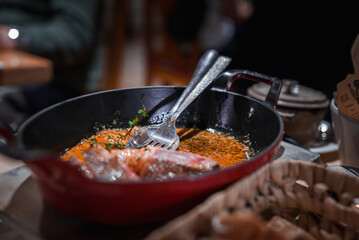 Cooking scene featuring a close up of a red skillet on stovetop with sauteed or fried food. Fresh...