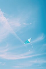 Person flying a kite in a blue sky, suitable for outdoor activities promotion
