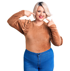 Young blonde plus size woman wearing casual sweater smiling cheerful showing and pointing with fingers teeth and mouth. dental health concept.