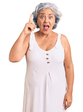 Senior woman with gray hair wearing casual clothes pointing finger up with successful idea. exited and happy. number one.