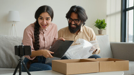 Couple bloggers customers open package box order online shopping delivery excited happy Arabian man...