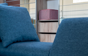 Cushioned furniture. Sections of built-in wardrobe close-up in home interior with blurred foreground with soft sofa