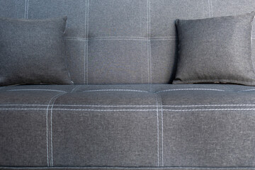 Cushioned furniture. Soft comfortable sofa with grey pillows close-up for relaxing in home interior