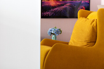 Cushioned furniture. Soft comfortable orange armchair close-up reflected in mirror of home interior