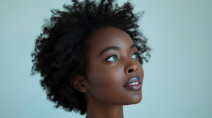 A black businesswoman looks up at a white background in profile