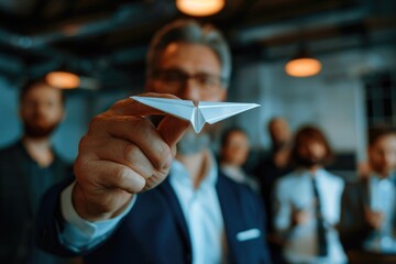 A man holding a paper airplane in front of a group of people. Ideal for business presentations - Powered by Adobe