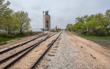 Fototapeta na wymiar Concrete grain elevator beside the train tracks at Seagraves, Texas, United States