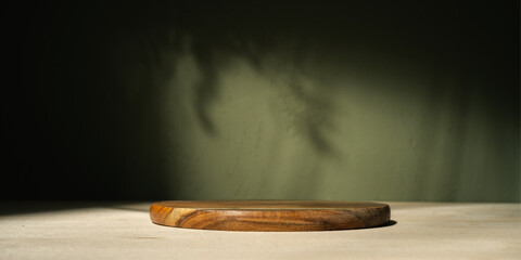 Round wood board for food, products or cosmetics against khaki green background.	